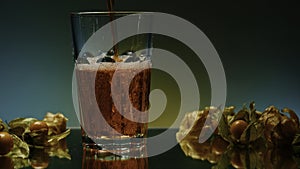 Bottling of alcoholic beverages. Stock clip. A green-lit background with a transparent glass around tangerines into