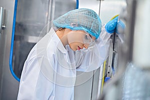 Bottling factory worker inspecting quality of water bottles before shipment. Reverse osmosis system used in plant. water