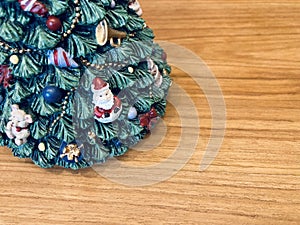 the bottom of the decorated green Christmas tree ceramic with a Santa Claus doll