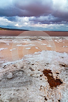 The bottom of the dried-up Kuyalnitsky estuary, covered with a layer of white self-precipitating table salt, clouds are reflected