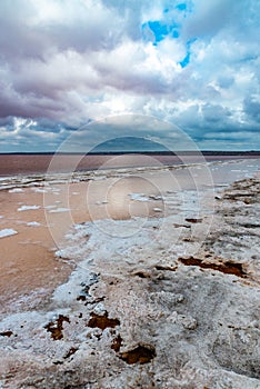 The bottom of the dried-up Kuyalnitsky estuary, covered with a layer of white self-precipitating table salt, clouds are reflected
