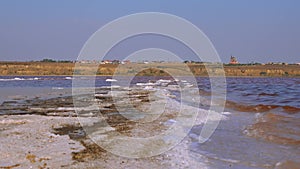 The bottom of a dying estuary, lake. Self-precipitating salt covers stones with a layer of white crystals, an environmental