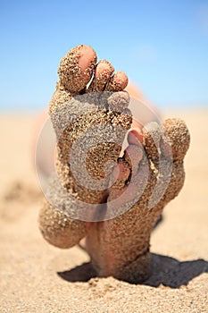 Bottom of feet covered with sand