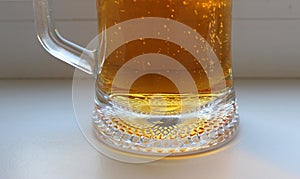 Bottom of large half-liter wet mug with fresh light beer closeup stock photo