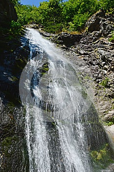 Pohľad vľavo dole na Šútovský vodopád, jeden z najvyšších vodopádov na Slovensku, počas letnej sezóny.