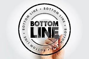 BOTTOM LINE stamp featuring a distressed circular border and repeated text around the ring, shown with a hand holding a marker,
