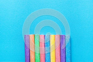 Bottom Row of Multicolored Chalks on Blue Background. Business Creativity Graphic Design Crafts Kids School Multiethnicity