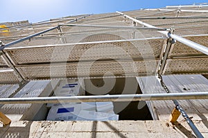 Bottom shot of thermal insulation material on the terrace of unfinished edifice with scaffold