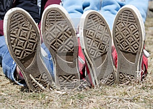 Bottom sole of teen sneakers outside in grass