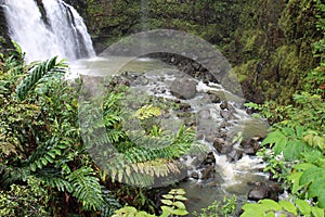 The bottom of Three Bears Falls, also known as Upper Waikani Falls, cascading into a pool of water and rushing downstream