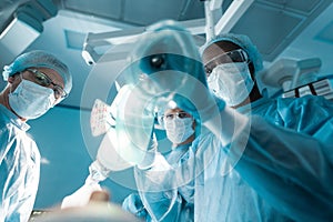 bottom view of african american anesthetist holding oxygen mask