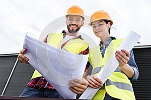 bottom view of architects in hardhats working with blueprints