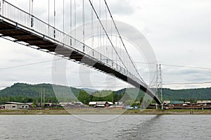 Bottom view of boardwalk pedestrian bridge across the river in the village