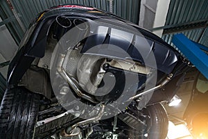 Bottom view of the car on a bifurcated exhaust system, rear bumper with a sports diffuser and nozzles in black. Tuning and atom