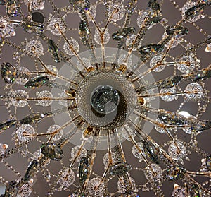 Bottom view at center of crystal chandelier lamp hang on white ceiling.