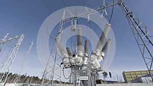 Bottom view of electricity grid and transformer on blue cloudy sky background. Action. Power line at the electricity