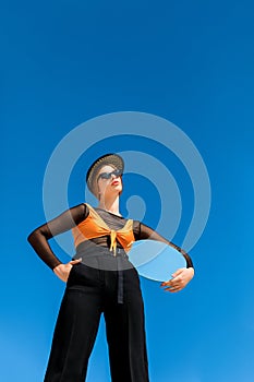 bottom view of fashionable girl posing with round mirror blue sky