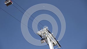 Bottom view of funiculars moving into different directions against the blue sky. Stock footage. Cable car with cabins