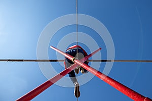 bottom view of a man tightrope walker with a pole