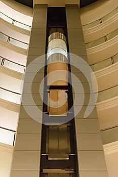 Bottom view of a modern glass elevator inside a modern building