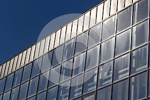 Bottom view of a modern skyscraper building with glass window against sky background for promotional content. Contemporary