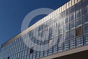 Bottom view of a modern skyscraper building with glass window against sky background for promotional content. Contemporary