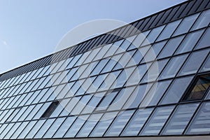 Bottom view of a modern skyscraper building with glass window against sky background for promotional content. Contemporary