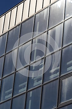 Bottom view of a modern skyscraper building with glass window against sky background for promotional content. Contemporary