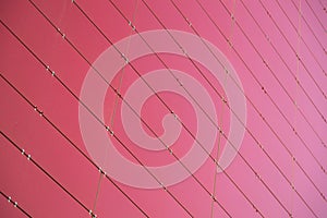 Bottom view of red metal wall of a building made of small metal rightangled sheets