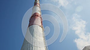 Bottom View Red and White Chimney with Ladder against Blue Sky
