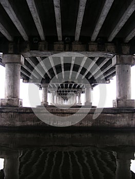 Bottom view of the reinforced concrete bridge over the river. Bridge piers