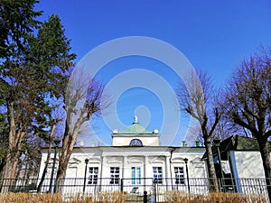 Bottom view shot of a white building and trees next to it in Spa Park, Jelenia GÃ³ra, Poland.