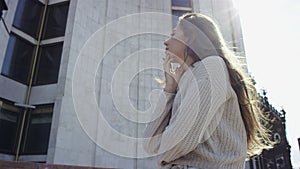 A bottom view slow motion close up shot with a camera floating of a dark-haired woman in white clothes standing near the