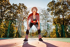 Bottom view of tired adult woman in sportswear doing aerobics on playground. Concept of healthy lifestyle and sport