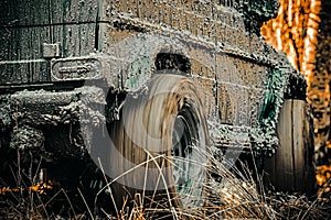 Bottom view to big offroad car wheel on country road and mountains backdrop. Mudding is off-roading through an area of photo