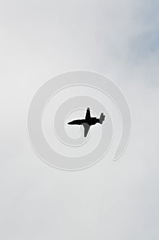 Silhouette of a private jet flying over tropical sea