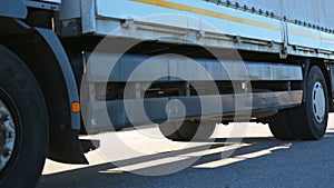 Bottom view of white truck driving at high speed on countryside road. Lorry with cargo trailer transporting goods at