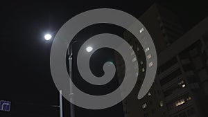 Bottom view from window car on a night city street. Stock footage. Driving along the residential houses and lanterns on