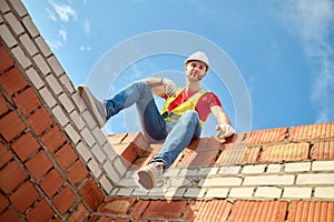 Bottom view of worker sitting at brick wall