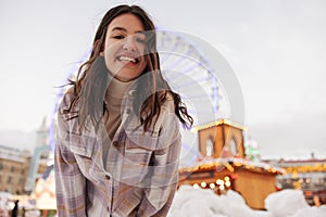 Bottom wiev of young caucasian girl smiling at camera spends leisure time outdoor in winter day.