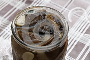 Botulism, food poisoning from canned foods concept. Opened Glass jar with homemade pickled mushrooms. Spoiled blackened forest