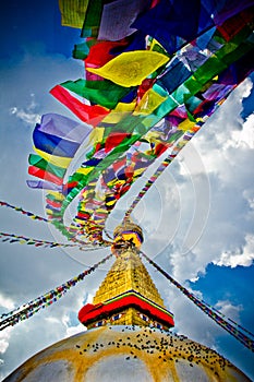 Boudhanath Stupa with prayer flages in the wind and deep blue skies, Kathmandu, Nepa