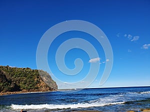 Boudi national park beach with blue clear sky surrounding sea and lots of greenness