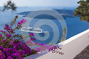 Bougainvillea adorn walkway as passenger cruise ship anchors off the coast of Greece