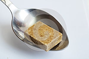 Bouillon cube in a spoon close up