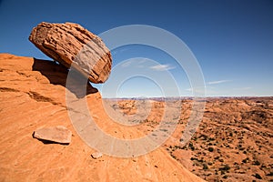 Boulder balanced on edge over sandstone cliff