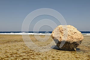 Boulder on beach by ocean