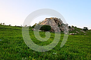 The boulder rock on the grassland sunset