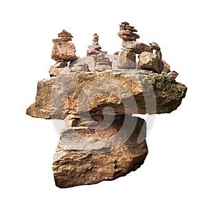 Boulder rock lying balancing on another boulder with towers made by tourists with stones