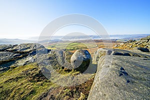 From the boulder strewn top of Stanage Edge over the foggy Derbyshire landscape